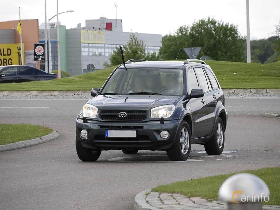 4x4 Toyota Land Cruiser safari vehicle parked along a paved mountain highway with the lush green terraced hillsides of Rwanda in the background